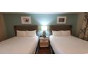 Two twin beds with nightstand and wall art at 2000 N Ocean Blvd. # 1206, Myrtle Beach, SC 29577