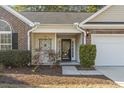 Front entry with black door, decorative ironwork, and manicured landscaping at 3169 Shorecrest Bay Dr., Murrells Inlet, SC 29576