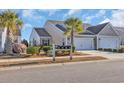 Two-story home with a two-car garage, landscaping, and palm trees at 4379 Livorn Loop # 4379, Myrtle Beach, SC 29579