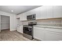 Bright kitchen with white cabinets, stainless steel appliances, and grey countertops at 48 Arbor Crest Ln., Tabor City, NC 28463