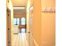Hallway with tile flooring and yellow walls leading into the living area and kitchen; a coat rack is mounted to the wall at 4870 Dahlia Ct. # 303, Myrtle Beach, SC 29577