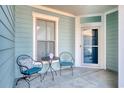 Relaxing front porch features two metal chairs and a small table at 6070 Tramonto St., Myrtle Beach, SC 29577