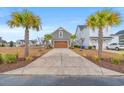 Detached two car garage featuring a large driveway and palm trees, adding to the curb appeal at 836 Crystal Water Way, Myrtle Beach, SC 29579