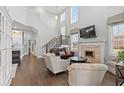 Bright living room featuring high ceilings, a fireplace, and elegant staircase leading to the second floor at 836 Crystal Water Way, Myrtle Beach, SC 29579