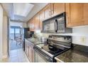 Condo kitchen featuring black appliances and wood cabinets at 1200 N Ocean Blvd. # 910, Myrtle Beach, SC 29577