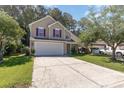 Tan two-story house with maroon shutters, attached garage, and landscaping at 1247 Brighton Ave., Myrtle Beach, SC 29588