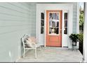 Front entrance with coral door and white bench at 406 Harbour View Dr., Myrtle Beach, SC 29579