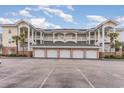 Front view of a three story condo building with parking and garages at 4872 Dahila Ct. # 301, Myrtle Beach, SC 29577