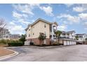 Condo building exterior with brick and siding, showing parking and landscaping at 4872 Dahila Ct. # 301, Myrtle Beach, SC 29577
