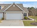 Tan colored exterior of house with two car garage and landscaped yard at 7015 River Bridge Ct, Myrtle Beach, SC 29579