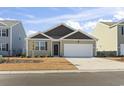 Tan house with dark brown roof and white garage door at 9179 Fort Hill Way, Myrtle Beach, SC 29579