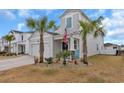 Two-story house with gray siding, palm trees, and a two-car garage at 1584 Swing Bridge Way, Myrtle Beach, SC 29588