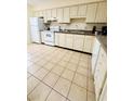 Bright kitchen with white cabinets, tiled floors, and modern appliances at 1650 Deercreek Rd., Surfside Beach, SC 29575