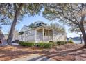 Gray house with white trim, landscaping, and large trees at 19 Cattail Ct. # 2B, Pawleys Island, SC 29585