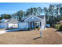 Gray siding house with white trim, two-car garage, and a small front porch at 2024 Willow Run Dr., Little River, SC 29566