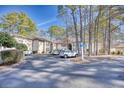 Exterior view of a condo building with a sign and parking at 204 Pipers Glenn # 204, Myrtle Beach, SC 29575