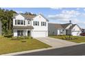 Two-story white house with a two-car garage and landscaped yard at 2871 Ellesmere Circle, Myrtle Beach, SC 29579