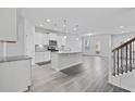 Open kitchen with white cabinets, granite island, and hardwood floors at 2871 Ellesmere Circle, Myrtle Beach, SC 29579