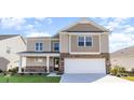 Two-story house with beige siding, stone accents, and a two-car garage at 382 Glacier Way, Conway, SC 29526