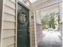 Green front door with wreath, leading to a courtyard with patio furniture at 4323 Lotus Ct. # G, Murrells Inlet, SC 29576