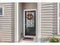 Inviting front door with wreath, 'WELCOME' mat, and sidelights creating a warm entryway at 4451 Livorn Loop # 4451, Myrtle Beach, SC 29579