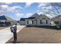 Tan house with a gray roof, a garage, and a well-maintained lawn at 469 Wallingford Circle, Myrtle Beach, SC 29588