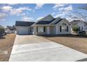 Tan house with a gray roof, a garage, and a well-maintained lawn at 469 Wallingford Circle, Myrtle Beach, SC 29588