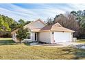 House with tan siding, white garage door, and green lawn at 518 Cordgrass Ln., Little River, SC 29566