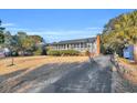 Ranch house with a spacious screened porch and driveway at 5515 Porcher Dr., Myrtle Beach, SC 29577