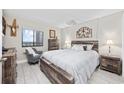 Bright bedroom with a cozy sitting chair, rustic wood furniture and scenic outside view at 5523 N Ocean Blvd. # 1601, Myrtle Beach, SC 29577