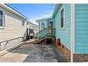 Side view of teal home with wooden steps and nautical decor at 703 3Rd Ave. S, North Myrtle Beach, SC 29582