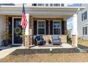 Relaxing front porch with seating and American flag at 771 Flowering Branch Ave., Little River, SC 29566