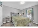 Comfortable bedroom featuring neutral walls, wood-look floors, and natural light from the large window at 789 University Forest Circle, Conway, SC 29526