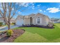 Well-maintained house with a manicured lawn and mature tree at 113 Barn Owl Ct., Carolina Shores, NC 28467