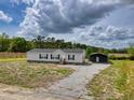 Single-story home featuring grey siding, black shutters, gravel driveway, and a matching storage structure at 122 Willie Mays Pl., Aynor, SC 29511