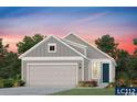 Exterior elevation of a single-Gathering home with gray siding, white trim, a dark blue front door, and a two-car garage at 1245 Lady Bird Way, North Myrtle Beach, SC 29582