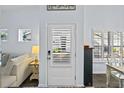 Front entry with white door and plantation shutters, view of living room at 1420 Jardine Loop, Little River, SC 29566