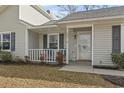 Inviting front porch with gray railings, a door, and landscaping at 603 Plantation Dr., Surfside Beach, SC 29575