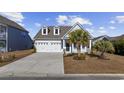 Craftsman style home with white siding, two-car garage, and palm trees at 692 Cherry Blossom Dr., Murrells Inlet, SC 29576