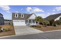 Two-story house with white siding, two-car garage, and landscaping at 692 Cherry Blossom Dr., Murrells Inlet, SC 29576