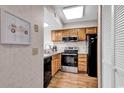 Galley kitchen featuring black appliances, wood cabinets and vinyl flooring at 4560 Greenbriar Dr. # 102-B, Little River, SC 29566