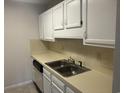 Efficient kitchen with white cabinets, double sink, and neutral countertops at 5001 Little River Rd. # W-402, Myrtle Beach, SC 29577
