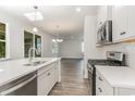 Open concept kitchen with island, stainless steel appliances, and white cabinets at 7015 Shooting Star Way, Myrtle Beach, SC 29579
