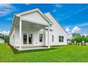 Covered patio with double doors, ceiling fan and lush green lawn at 888 Agostino Dr., Myrtle Beach, SC 29579