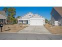 Well-kept single-story home with a manicured lawn, two-car garage, and inviting blue front door at 1141 Bethpage Dr., Myrtle Beach, SC 29579