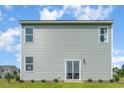 Rear view of a two-story house with light green siding and a sliding glass door at 1457 Nokota Dr., Conway, SC 29526