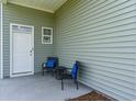 Small side porch with two chairs and a table, adjacent to a white door at 1457 Nokota Dr., Conway, SC 29526