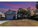 House exterior at sunset, palm trees, two-car garage at 402 Ocean Pointe Ct., North Myrtle Beach, SC 29582