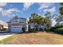 Two-story home with balcony, palm trees, and a garage at 402 Ocean Pointe Ct., North Myrtle Beach, SC 29582