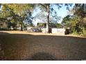 Large grassy backyard with mature trees and wooden fence at 4819 Walnut St., Loris, SC 29569